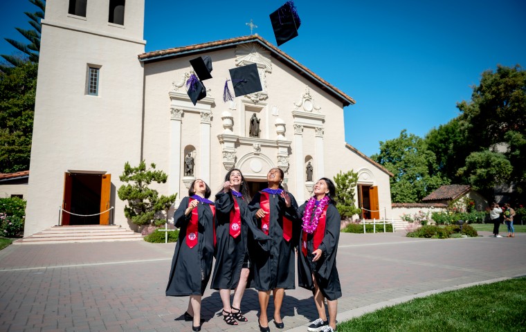 四名法律系女毕业生在代表团前向空中投掷帽子