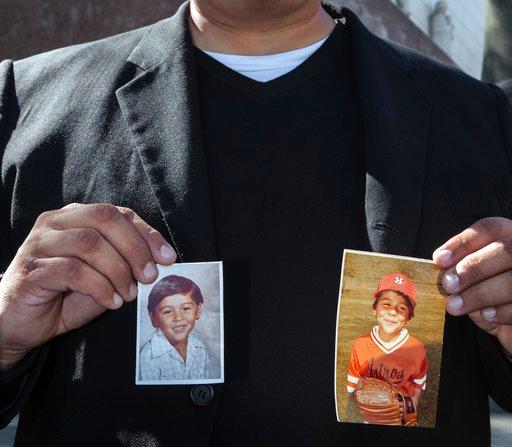 迈克尔·杜兰是洛杉矶罗马天主教大主教管区性侵案的原告，他举起自己小时候的照片(美联社图片/达米安·多瓦甘内斯，档案)。