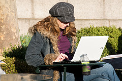 一名女子在外面使用笔记本电脑