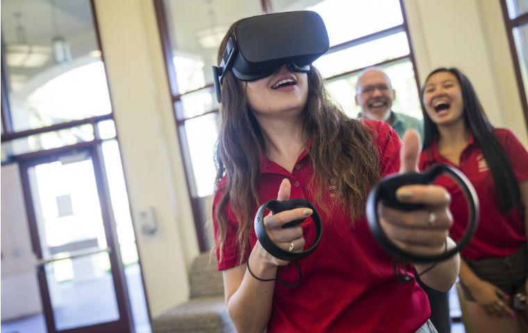 学生使用VR眼镜与后面的观察者图像链接到故事