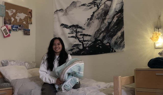 Isabel Andaya '24在Graham Hall的房间里拿着她最喜欢的毯子。