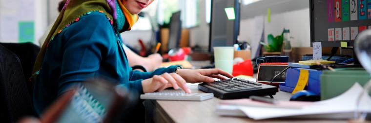 一名戴头巾的女子坐在一家初创公司的电脑前