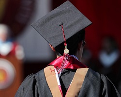 一个人戴着传统的毕业帽和毕业礼服。
