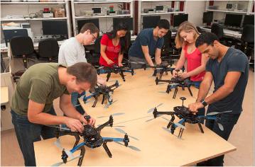 六名学生在机器人系统实验室研究八翼直升机